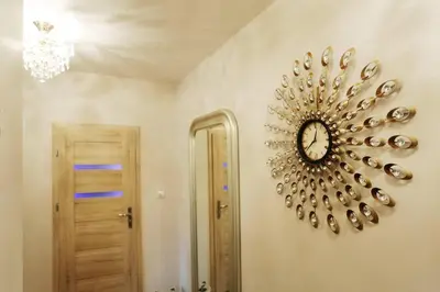 a clock on a wall next to a door at Ekskluzywny Apartament w centrum z balkonem i parkingiem in Kraków