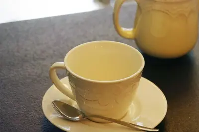 a coffee cup on a plate with a spoon at Ekskluzywny Apartament w centrum z balkonem i parkingiem in Kraków