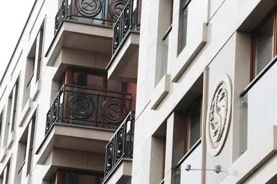 a building with balconies and a clock on the side at Ekskluzywny Apartament w centrum z balkonem i parkingiem in Kraków