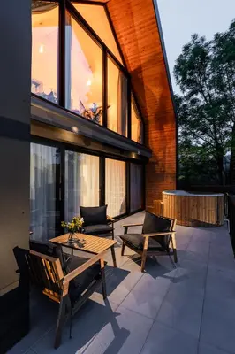 a patio with a wooden table and chairs on a building at Kurka Chata in Nowy Targ