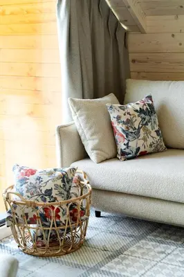 a couch with two pillows and a basket at Kurka Chata in Nowy Targ