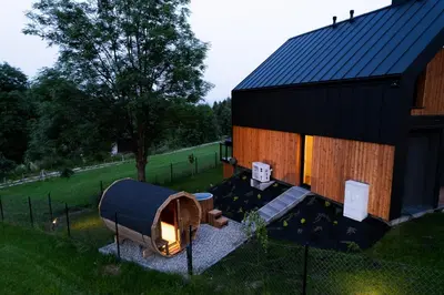 a large black building with a fireplace in front of it at Kurka Chata in Nowy Targ