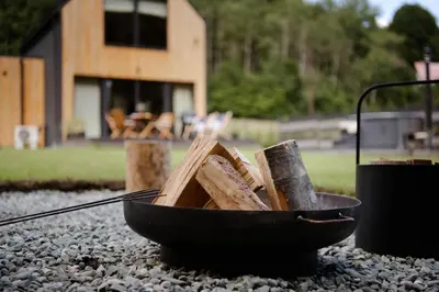 a bowl full of wood sitting on a pile of rocks at Babia Rest - całoroczny domek z balią z jacuzzi in Zawoja