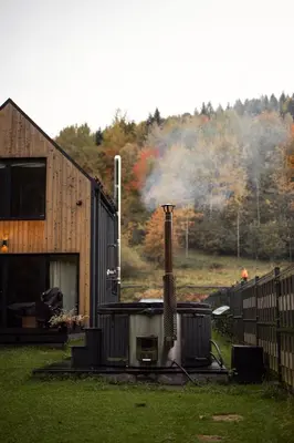 a house with a smoker in front of a house at Babia Rest - całoroczny domek z balią z jacuzzi in Zawoja