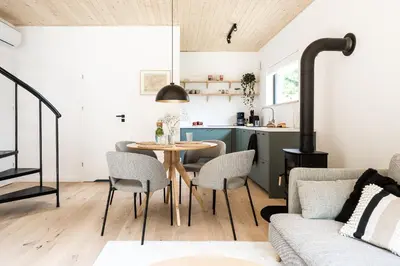a kitchen and living room with a table and chairs at Babia Rest - całoroczny domek z balią z jacuzzi in Zawoja