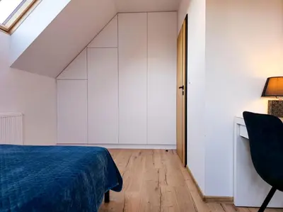 a bedroom with a bed and a desk and a chair at Panorama Beskidu in Skrzydlna