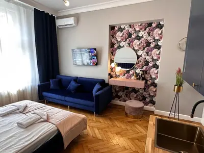 a bedroom with a blue couch and a mirror at Premium Apartment in Spiski Palace in Kraków