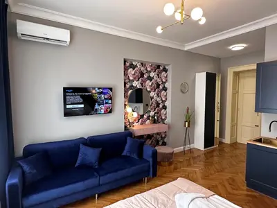 a living room with a blue couch and a mirror at Premium Apartment in Spiski Palace in Kraków