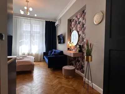 a living room with a blue couch and a mirror at Premium Apartment in Spiski Palace in Kraków
