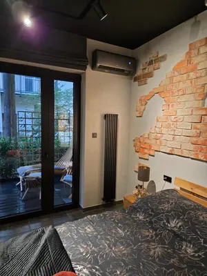 a bedroom with a brick wall with a bed and a fireplace at Luxury Apartments, self check in 24 h & Free Parking in Kraków