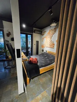 a bedroom with a bed and a brick wall at Luxury Apartments, self check in 24 h & Free Parking in Kraków