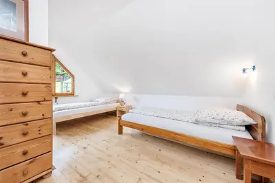 a bedroom with two beds and a wooden dresser at Chata pod 7 lipami in Jaworzna
