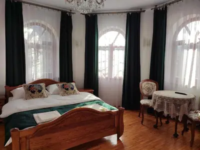a bedroom with a bed and a table and windows at Willa Emil z BALIĄ ogrodową in Stróża