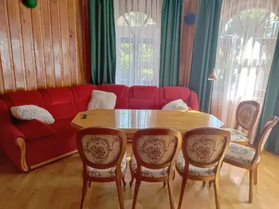 a living room with a table and a red couch at Willa Emil z BALIĄ ogrodową in Stróża