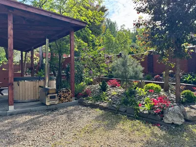a garden with a gazebo and a bunch of flowers at Willa Emil z BALIĄ ogrodową in Stróża