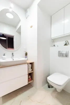 a white bathroom with a sink and a toilet at Nowohucka Apartament in Kraków