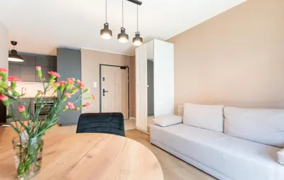 a living room with a white couch and a table at Nowohucka Apartament in Kraków