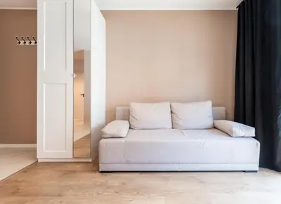 a white couch in a room with a mirror at Nowohucka Apartament in Kraków