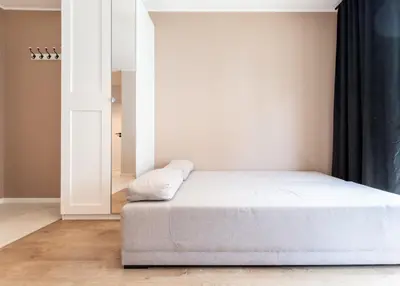 a bedroom with a white bed and a mirror at Nowohucka Apartament in Kraków