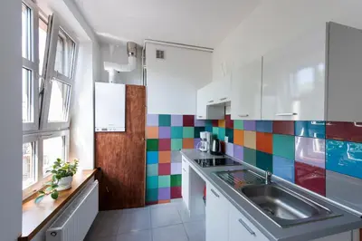 a kitchen with a sink and a colorful tile wall at Bianca Studio in Kraków
