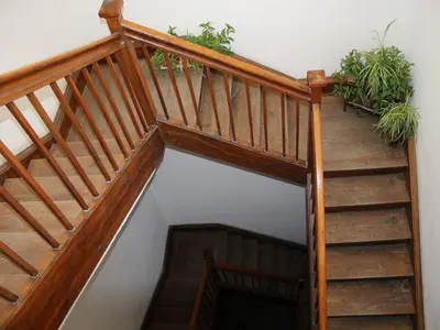 a wooden staircase with wooden railings and potted plants at Bianca Studio in Kraków