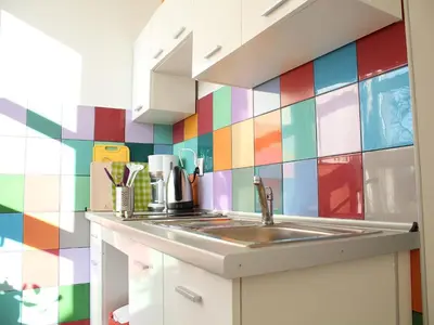 a kitchen with a sink and a colorful tiled wall at Bianca Studio in Kraków