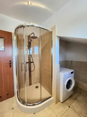 a shower in a bathroom with a washing machine at Cozy Apartament Country 6persons close to airport in Kraków