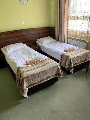 two beds in a hotel room withacers at Zajazd Miechus in Miechów