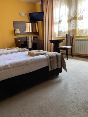 a bedroom with a bed and a table and a chair at Zajazd Miechus in Miechów