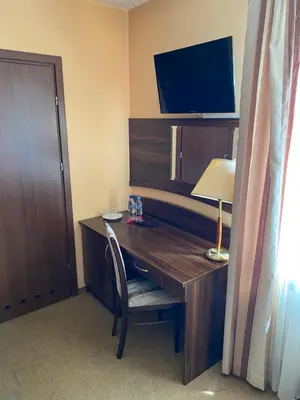 a room with a desk with a lamp and a television at Zajazd Miechus in Miechów