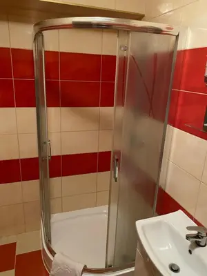 a shower with a glass door next to a sink at Zajazd Miechus in Miechów