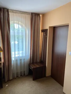 a room with a window and a dresser and a door at Zajazd Miechus in Miechów