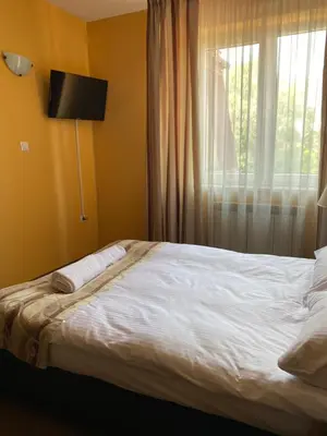 a bedroom with a white bed with a window at Zajazd Miechus in Miechów
