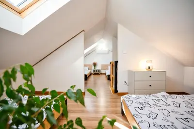 an attic bedroom with a bed and a room at 3 Stodoły-domek 1 in Zator
