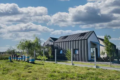 a black and white building in a field at 3 Stodoły-domek 1 in Zator