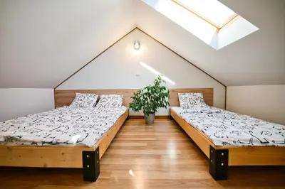 two beds in a room with a skylight at 3 Stodoły-domek 1 in Zator