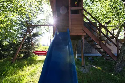 a blue dress is standing in front of a tree house at 3 Stodoły-domek 1 in Zator