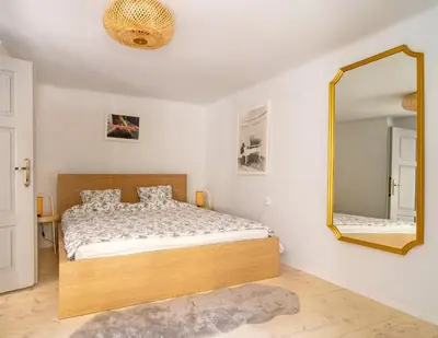a bedroom with a bed and a mirror at Tomte - scandinavian apartment in Kraków