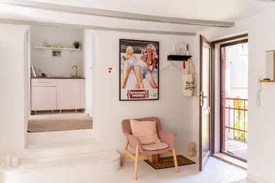 a living room with a chair and a picture on the wall at Tomte - scandinavian apartment in Kraków