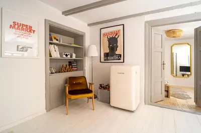 a living room with a refrigerator and a chair at Tomte - scandinavian apartment in Kraków