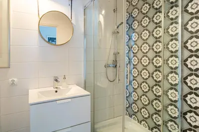 a bathroom with a shower and a sink and a mirror at Tomte - scandinavian apartment in Kraków