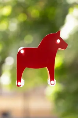 a red plastic horse ornament with lights on it at Tomte - scandinavian apartment in Kraków