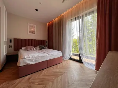 a bedroom with a bed and a large window at Resto Inn - Smart apartamenty blisko Energylandii in Po”łwieś