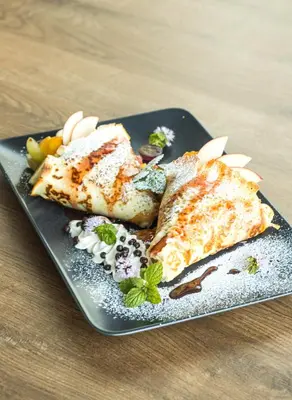 a black plate with three pieces of food on it at Resto Inn - Smart apartamenty blisko Energylandii in Po”łwieś