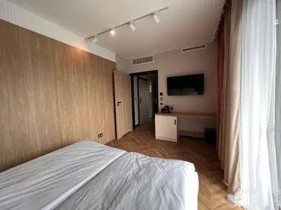 a bedroom with a bed and a flat screen tv at Resto Inn - Smart apartamenty blisko Energylandii in Po”łwieś