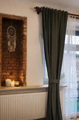a room with a window with a curtain and candles at Nice Place in Kraków