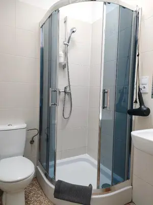a bathroom with a shower with a toilet and a sink at Nice Place in Kraków