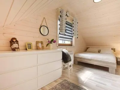 a bedroom with a bed and a bench in a room at Domek Leniuchowo in Rabka