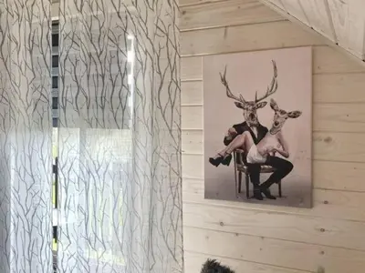 a painting of a deer and a man sitting on a chair at Domek Leniuchowo in Rabka