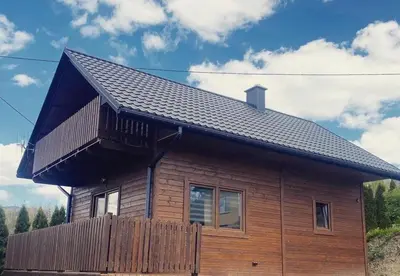 a wooden house with a balcony on top of it at Domek Leniuchowo in Rabka